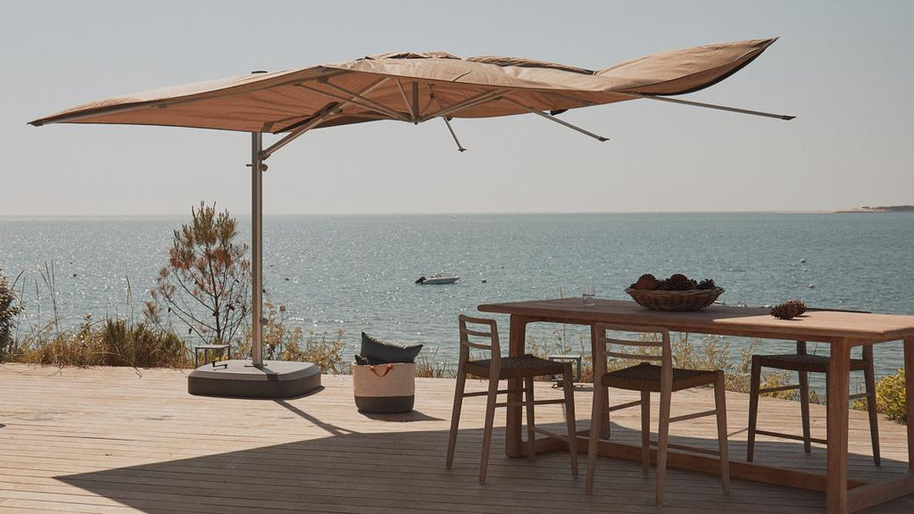 parasol shading table and chairs with sea in the distance