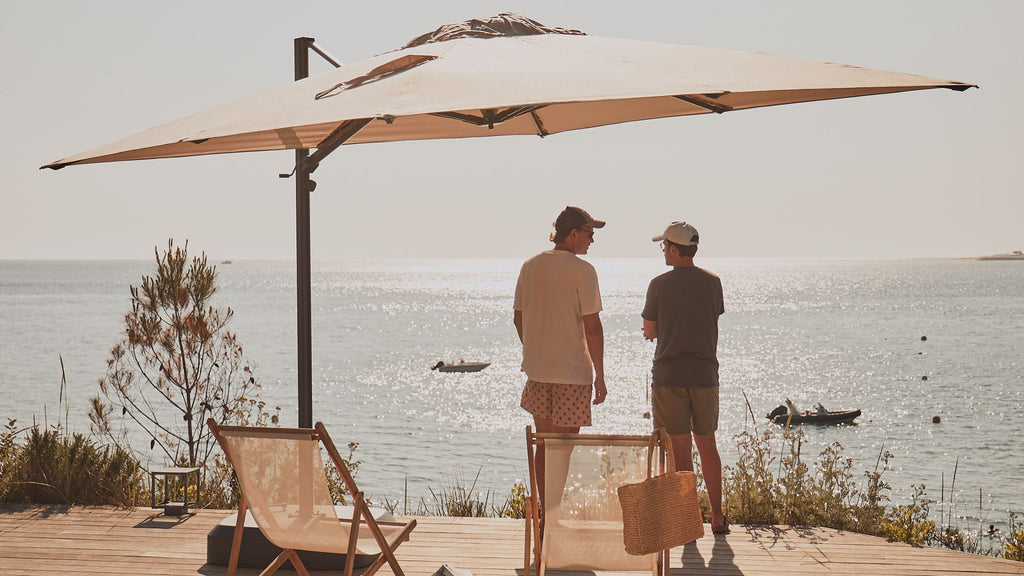 Two men talking on their terrace under a parasol