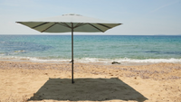 A garden parasol on the sand standing without a stand